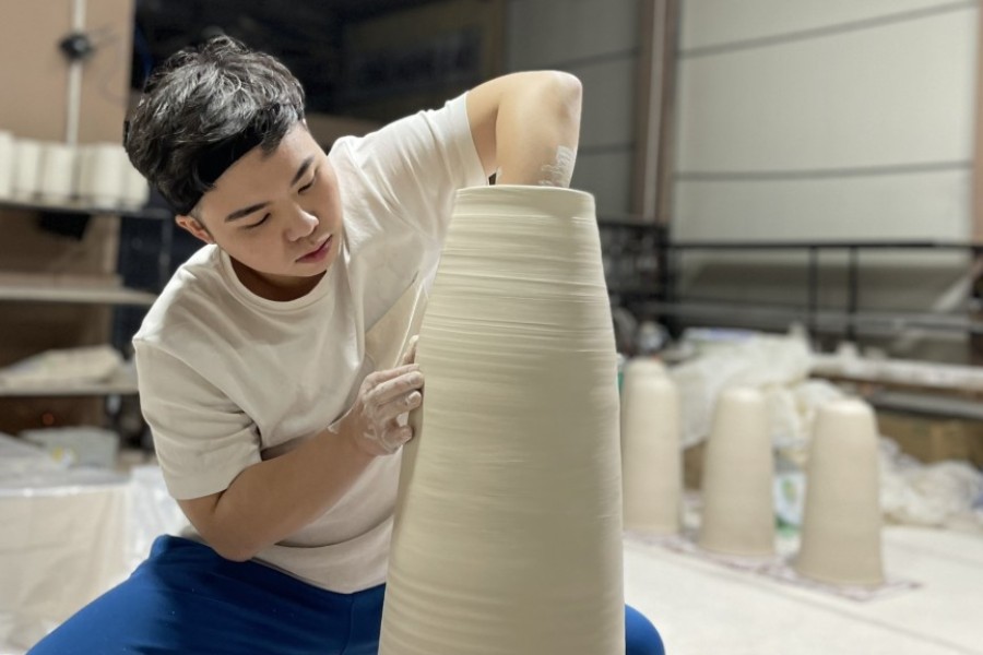 Local artisan carefully crafting each vase